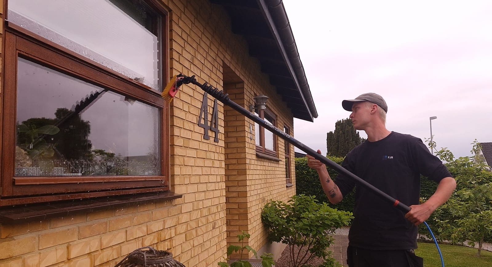 Vinduespudsning af vindue med vandførende teleskopstang på enfamiliehus på Fyn