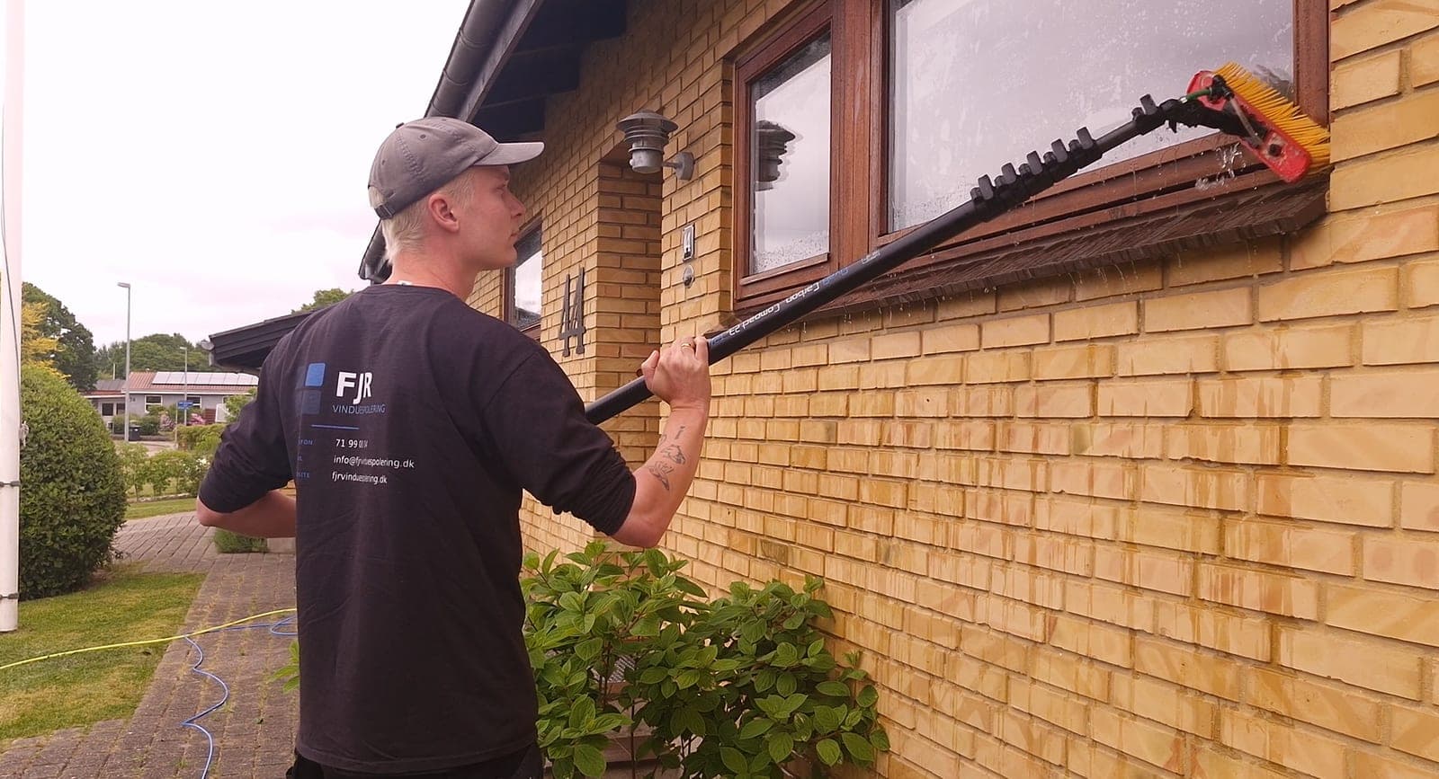 Vinduespudser fra FJR Vinduespolering pudser vindue, FJR logo på ryggen, på Fyn